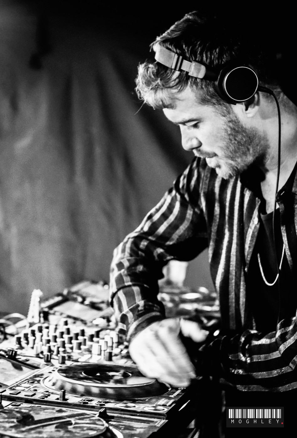 Black and white photograph of a DJ mixing at a club night