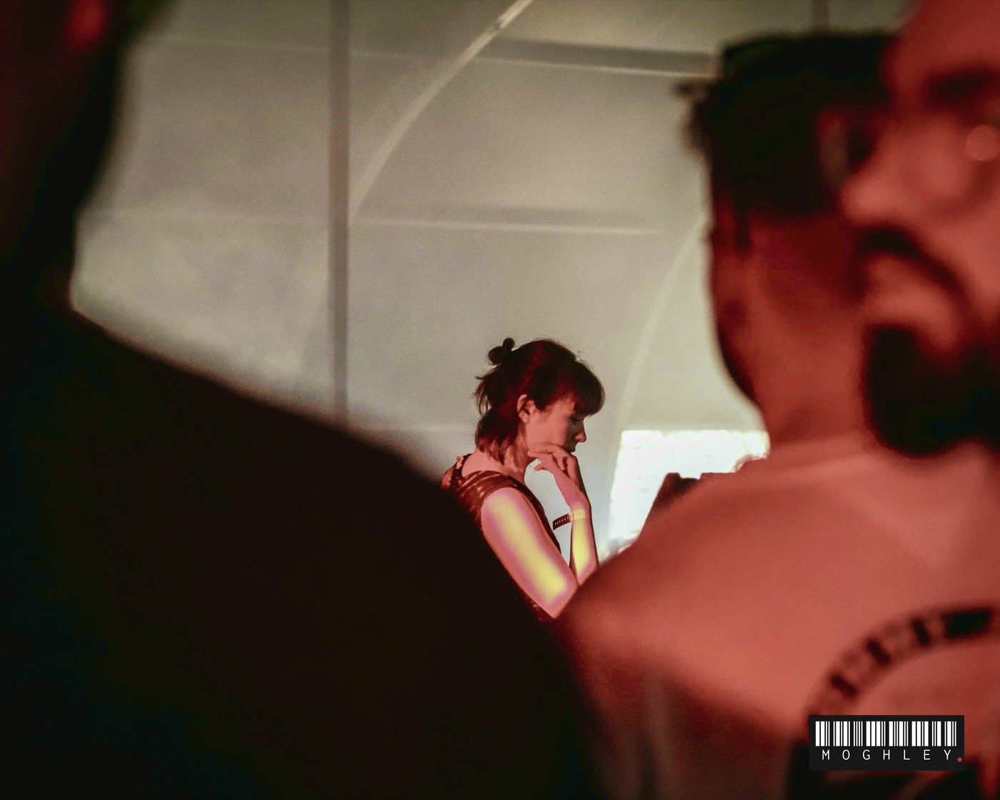 Two people talking at a nightlife event, warm red lighting